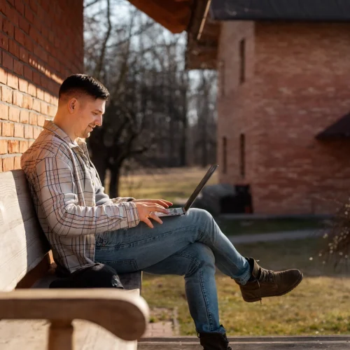 full-shot-smiley-man-using-laptop